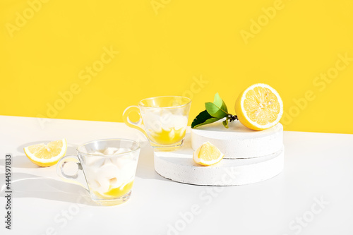 Lemon mousse or ice cream in a glass cups on yellow background. Traditional Italian recipe of lemon tiramisu or granita. Delicious summer dessert.