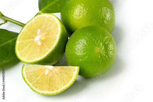 Close up natural fresh lime with sliced, green leaf isolated on white background..