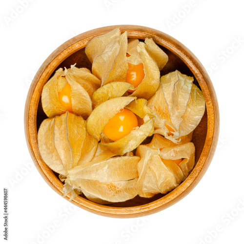 Cape gooseberries with partly open calyx, in a wooden bowl. Fresh fruits of Physalis peruviana, also golden, inca and ground berry, uchuva, poha, and rasbhari. Used as a garnish or dessert. Food photo photo