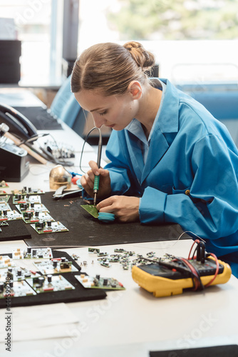 Worker in electronics manufacturing soldering a component for the prototype series by hand photo