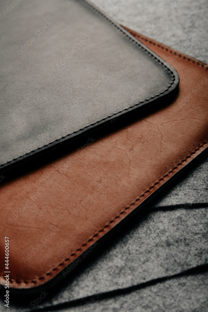 Close up of two leather handmade cases on grey background
