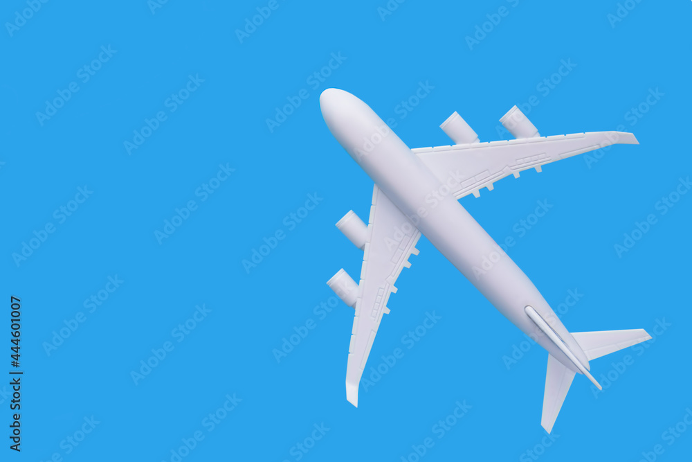Fototapeta premium model of passenger plane on blue background.Travel concept
