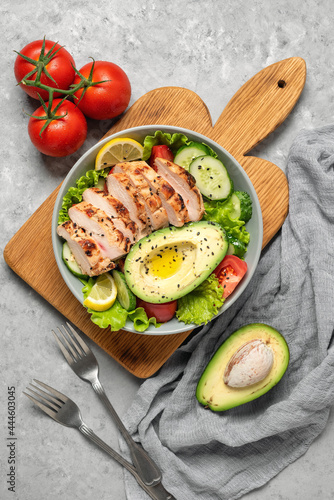 Fresh vegetable salad with grilled chicken. Ketogenic diet. Healthy food concept. Gray grunge background. Top view, flat lay.