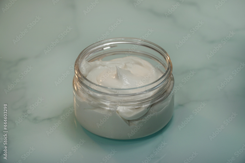 Natural homemade face cream or body lotion on blue marble background. Natural homemade face cream or body lotion on blue marble background.