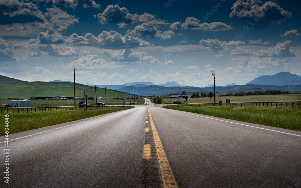 Fototapeta premium An intersection on ranch land along Highway 22 near the Livingstone mountain range and Alberta East slopes of the Canadian Rockies during the summer.