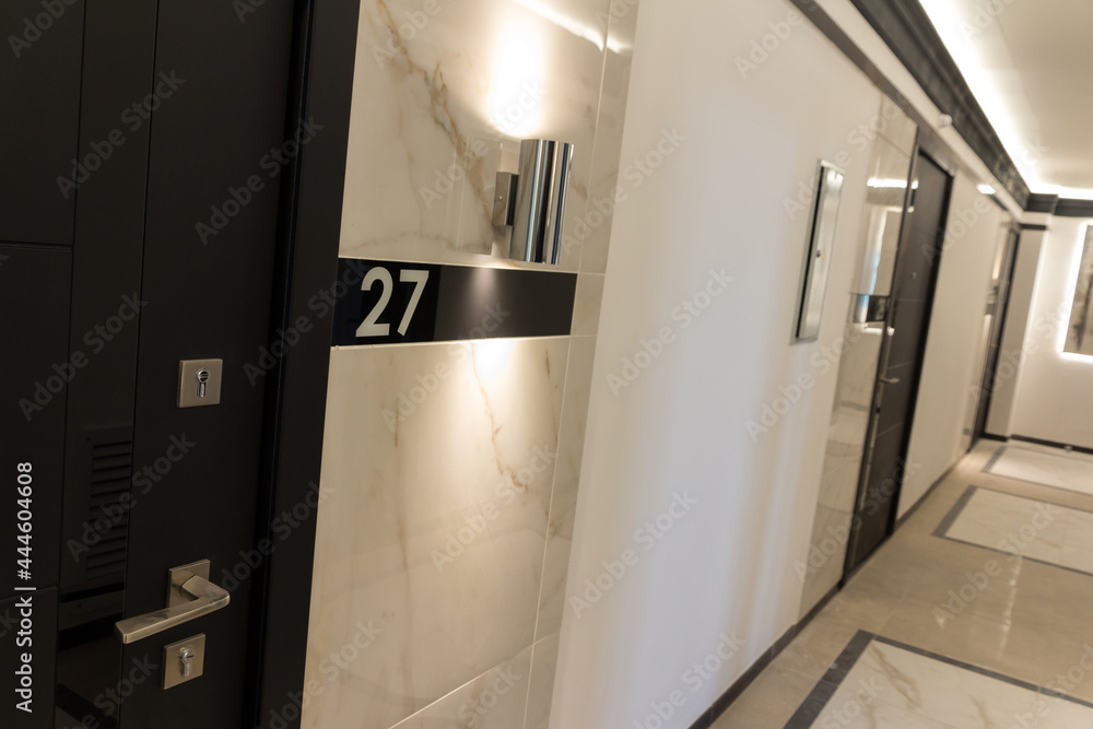 Hotel corridor with apartment number. Closed doors in the hallway. Hospitality business Hotel corridor with apartment number. Closed doors in the hallway. Hospitality business