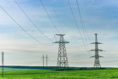 High voltage electric pylon and electrical wire at green field. Electricity pylon and High voltage grid tower with wire cable. Power and energy concept