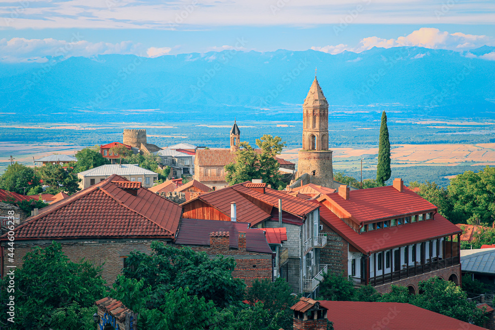 View of Sighnaghi in winery region of Georgia, Kakheti, during sunset in summer with Caucasus mountains in the background