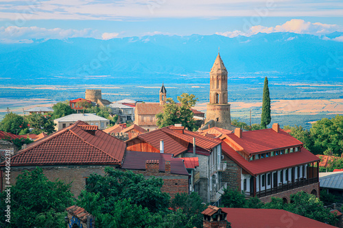 View of Sighnaghi in winery region of Georgia, Kakheti, during sunset in summer with Caucasus mountains in the background photo