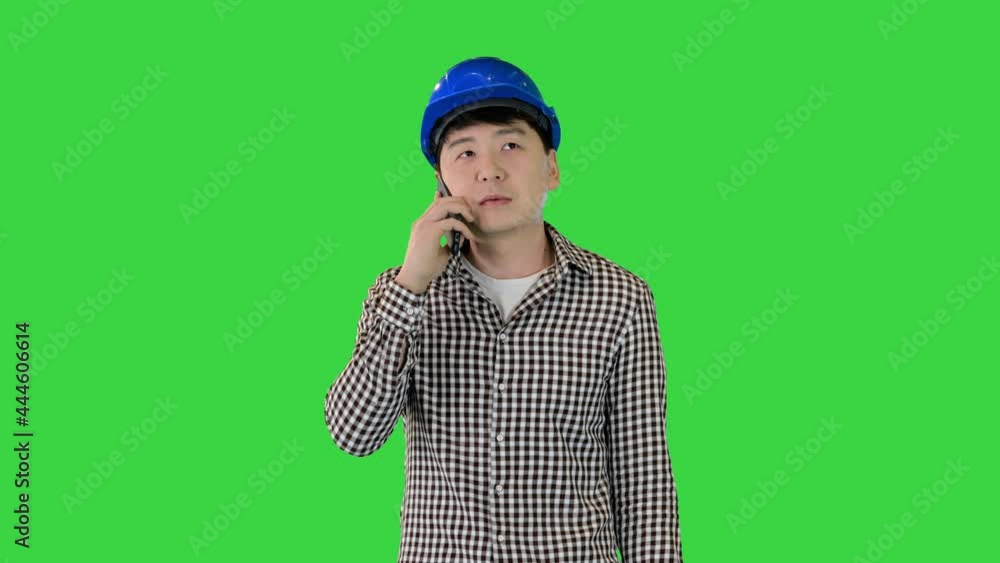 Asian construction worker making a call on a Green Screen, Chroma Key. Asian construction worker making a call on a Green Screen, Chroma Key.