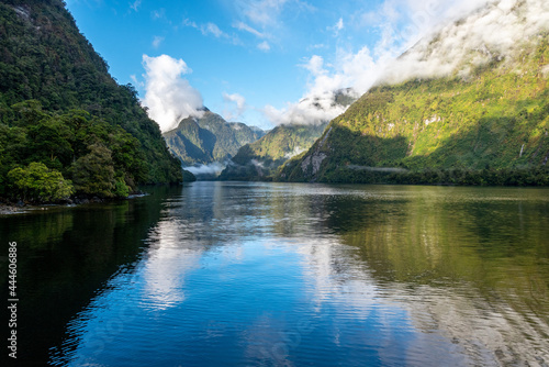 A new morning dawning at Doutful Sound  clouds hanging low in the mountains  Fiordland National Park  New Zealand