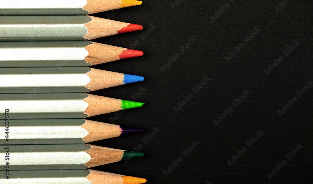 Obraz premium Wooden color pencils close-up. Border composition with black background. Top view and copy space photo