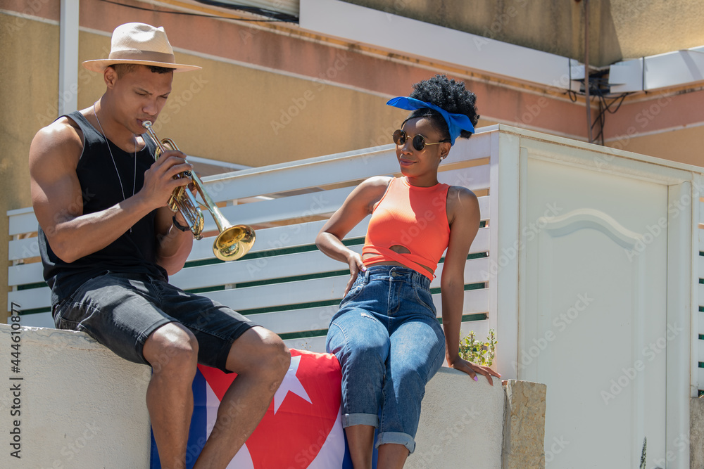 Obraz premium Latina woman watching a latino man playing a trumpet: Selective focus. Music and diversity concept.