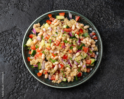 Quinoa white bean salad with cherry tomatoes, cucumber, red onion and herbs. Healthy vegan food