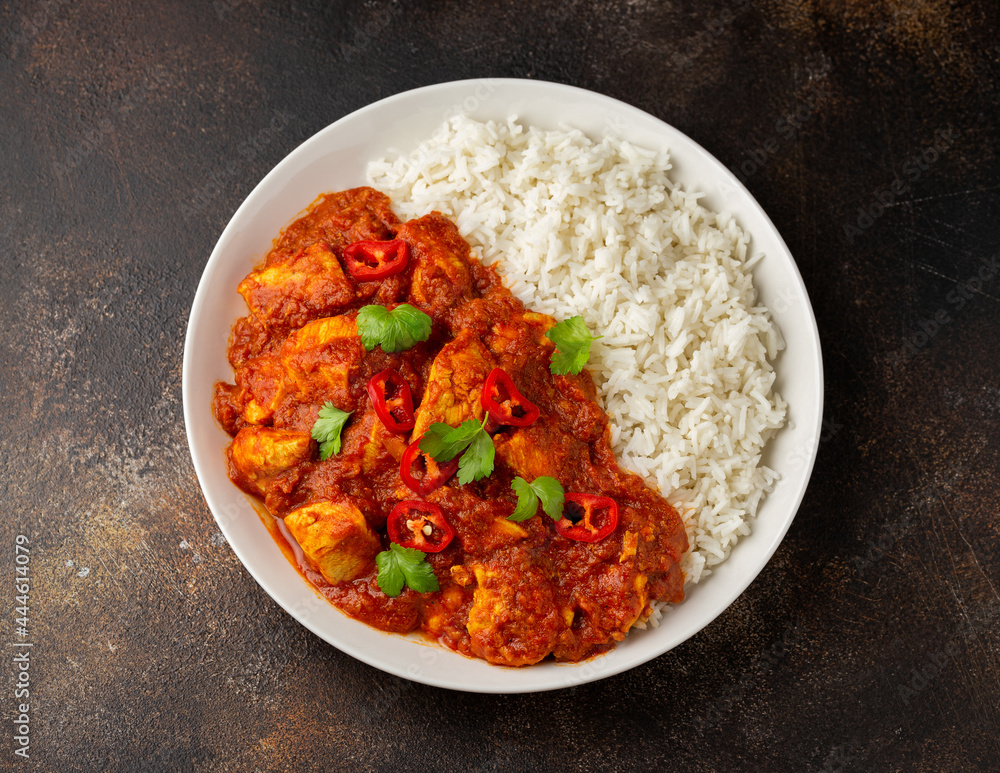 Spicy Chicken Pathia curry with basmati rice in a white plate. healthy food. Spicy Chicken Pathia curry with basmati rice in a white plate. healthy food.