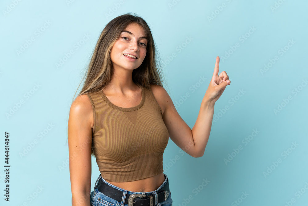Young caucasian woman isolated on blue background showing and lifting a finger in sign of the best Young caucasian woman isolated on blue background showing and lifting a finger in sign of the best