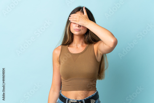 Young caucasian woman isolated on blue background covering eyes by hands. Do not want to see something © luismolinero