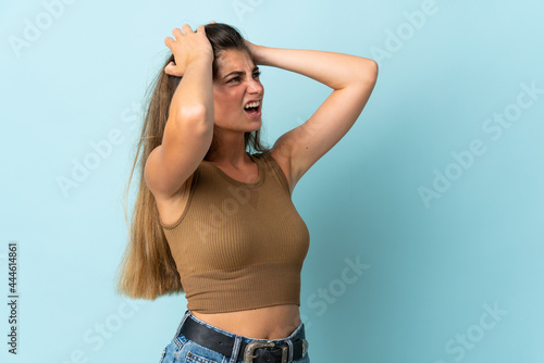 Young caucasian woman isolated on blue background stressed overwhelmed