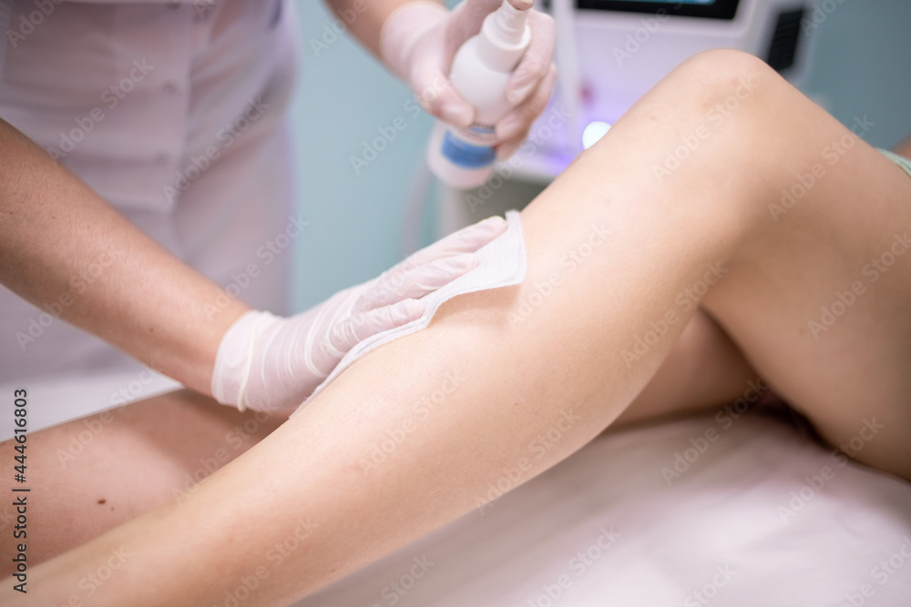 Fototapeta premium Treatment of a woman's leg before laser hair removal.