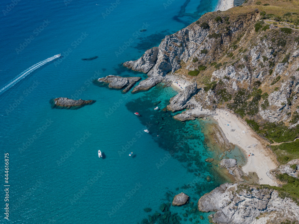 Aerial view of Capo Vaticano, Calabria, Italy. Lighthouse and promontory. Rocks overlooking the sea. Praia I Focu beach and A Ficara beach. Boats and bathers and crystal clear sea. Costa degli Dei