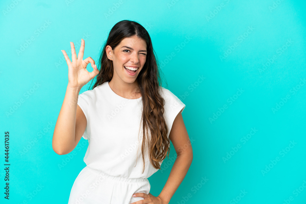Young caucasian woman isolated on blue background showing ok sign with fingers Young caucasian woman isolated on blue background showing ok sign with fingers