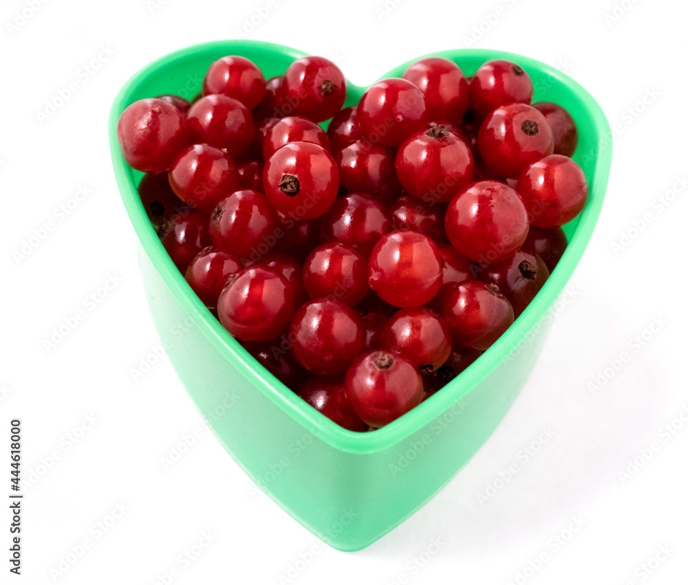 Red currant heart isolated on a white background.A heart-shaped cookie mold filled with red currants.Garden fresh berries, bright and shiny. Red currant heart isolated on a white background.A heart-shaped cookie mold filled with red currants.Garden fresh berries, bright and shiny.