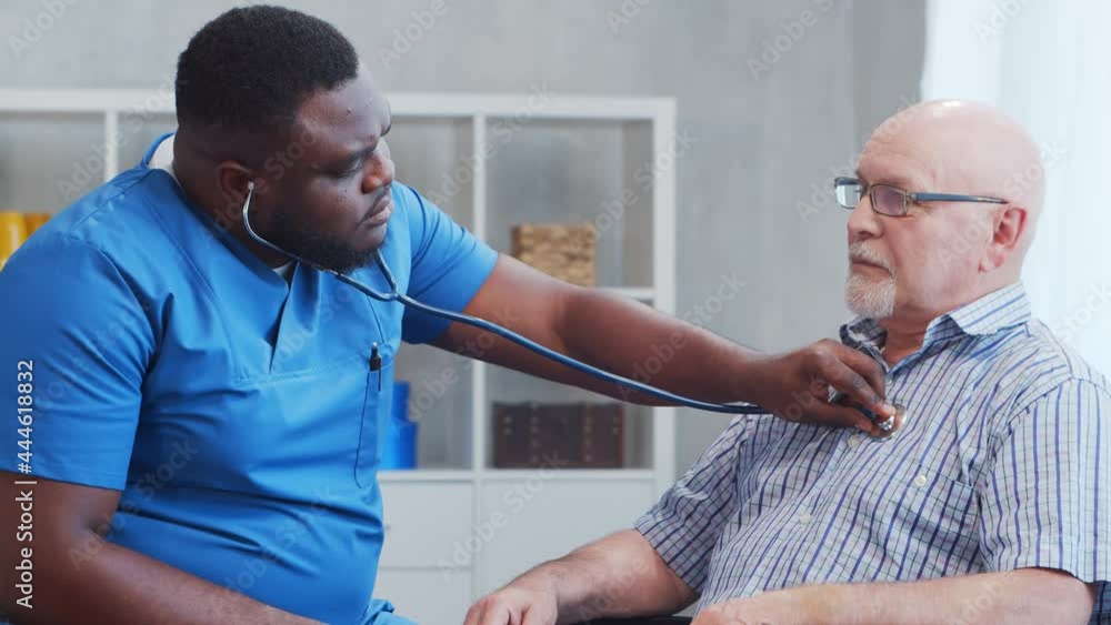 African-American caregiver and old disabled man in a wheelchair. Professional nurse and handicapped patient in a nursing home. Assistance, rehabilitation and health care. African-American caregiver and old disabled man in a wheelchair. Professional nurse and handicapped patient in a nursing home. Assistance, rehabilitation and health care.
