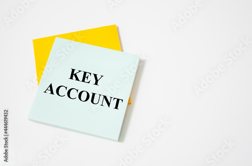 key account text written on a white notepad with colored pencils and a yellow background. word