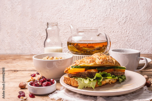 Healthy breakfast concept. Morning good mood with tea, croissant, granola, milk, and jam