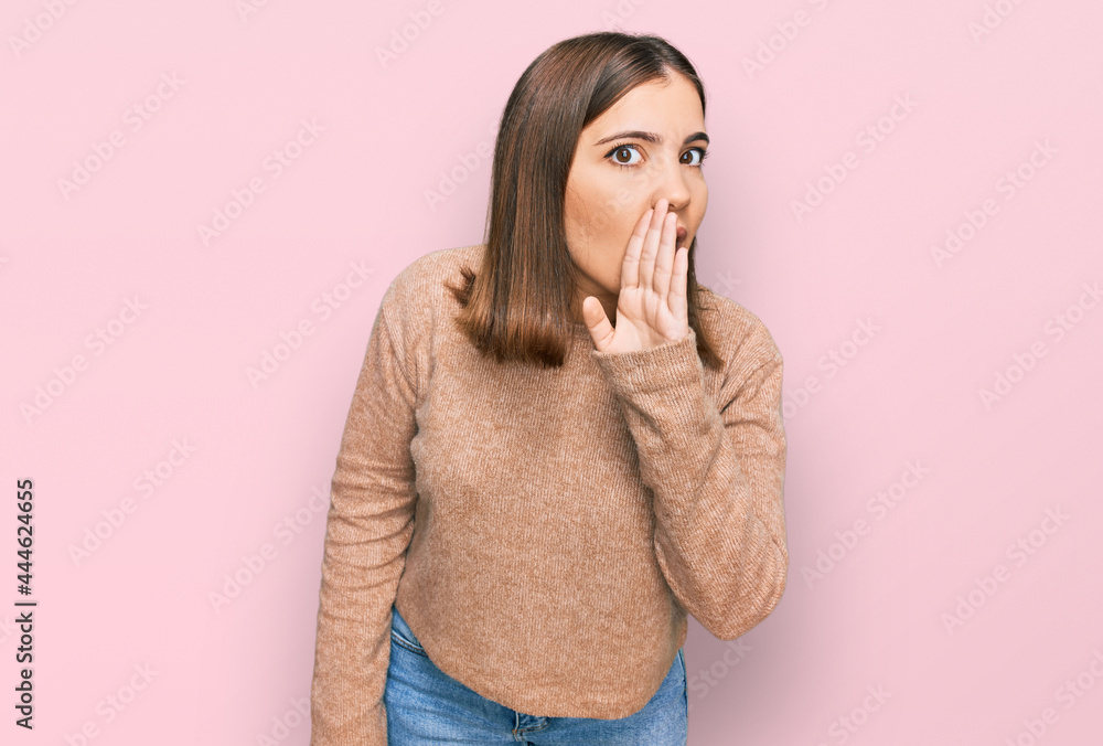 Young beautiful woman wearing casual clothes hand on mouth telling secret rumor, whispering malicious talk conversation Young beautiful woman wearing casual clothes hand on mouth telling secret rumor, whispering malicious talk conversation