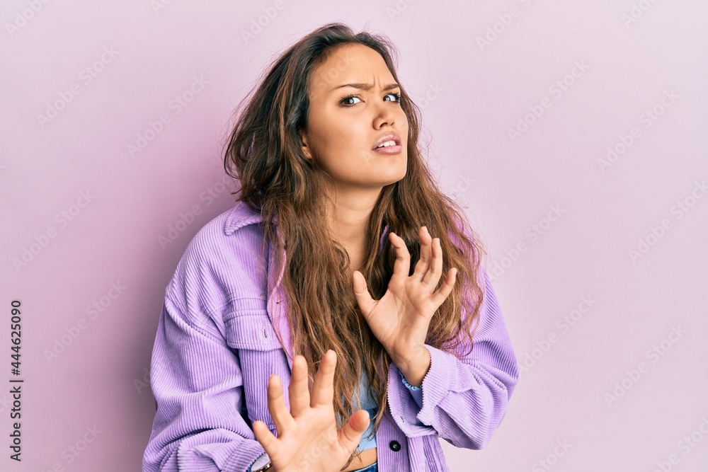 Young hispanic girl wearing casual clothes disgusted expression, displeased and fearful doing disgust face because aversion reaction. with hands raised Young hispanic girl wearing casual clothes disgusted expression, displeased and fearful doing disgust face because aversion reaction. with hands raised
