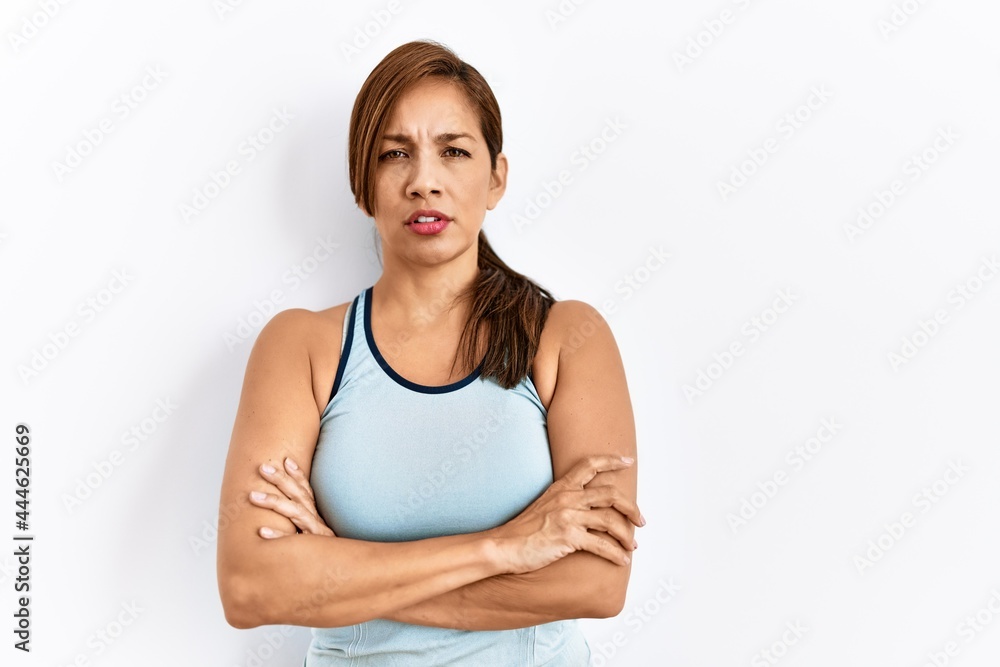 Young latin woman wearing sporty clothes over isolated background skeptic and nervous, disapproving expression on face with crossed arms. negative person. Young latin woman wearing sporty clothes over isolated background skeptic and nervous, disapproving expression on face with crossed arms. negative person.
