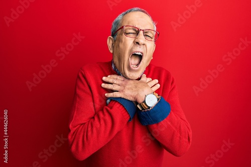 Handsome senior man with grey hair wearing casual clothes and glasses shouting and suffocate because painful strangle. health problem. asphyxiate and suicide concept. © Krakenimages.com