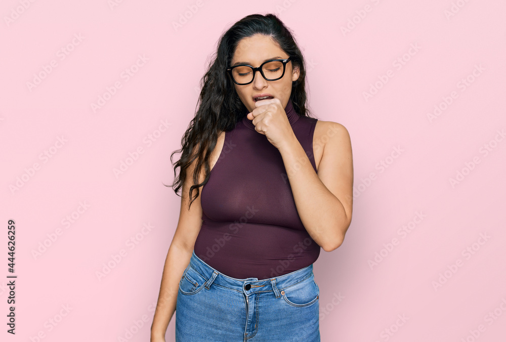 Brunette young woman wearing casual clothes and glasses feeling unwell and coughing as symptom for cold or bronchitis. health care concept. Brunette young woman wearing casual clothes and glasses feeling unwell and coughing as symptom for cold or bronchitis. health care concept.