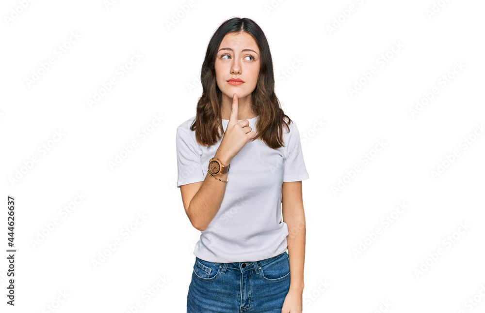 Young beautiful woman wearing casual white t shirt thinking concentrated about doubt with finger on chin and looking up wondering Young beautiful woman wearing casual white t shirt thinking concentrated about doubt with finger on chin and looking up wondering