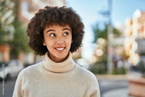 Young hispanic girl smiling happy standing at the city.