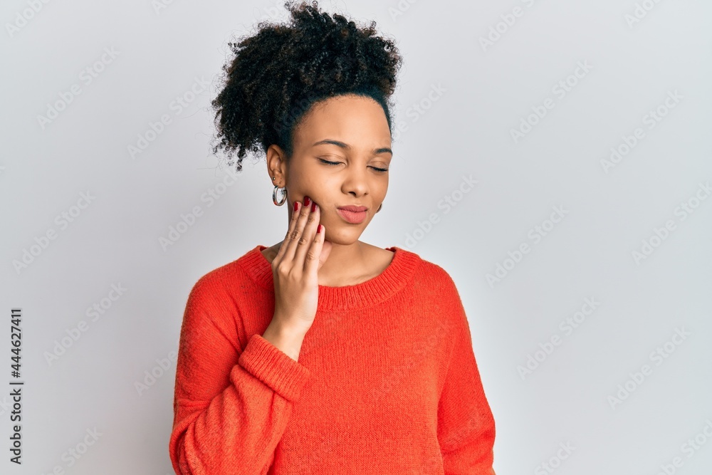 Young african american girl wearing casual clothes touching mouth with hand with painful expression because of toothache or dental illness on teeth. dentist Young african american girl wearing casual clothes touching mouth with hand with painful expression because of toothache or dental illness on teeth. dentist