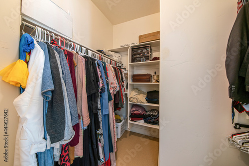 Small walk in closet with clothing rod and shelves