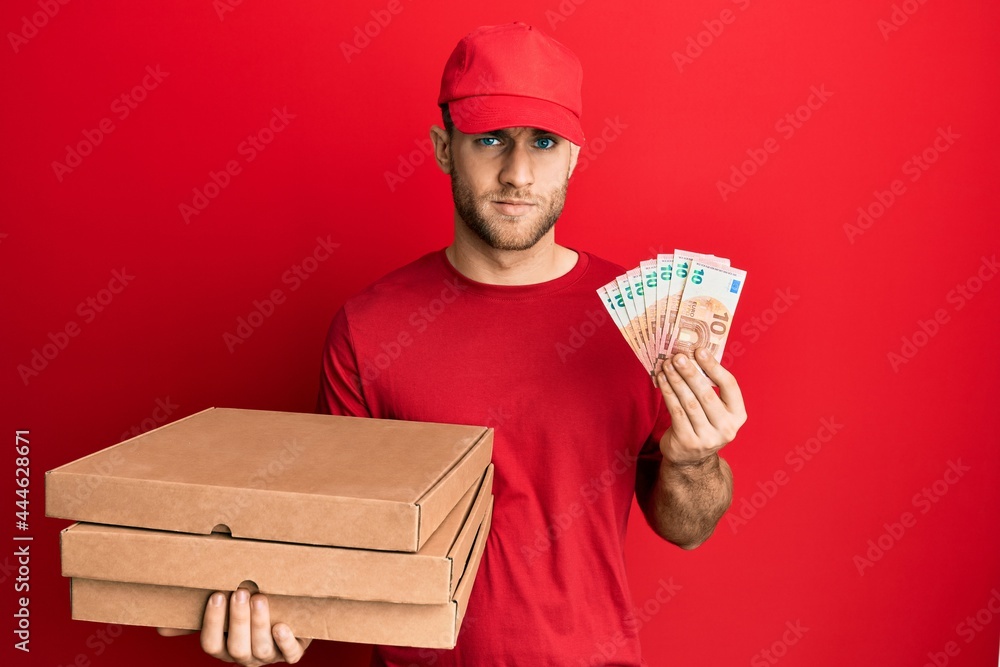 Young caucasian man holding take away food and 10 euros banknotes skeptic and nervous, frowning upset because of problem. negative person. Young caucasian man holding take away food and 10 euros banknotes skeptic and nervous, frowning upset because of problem. negative person.