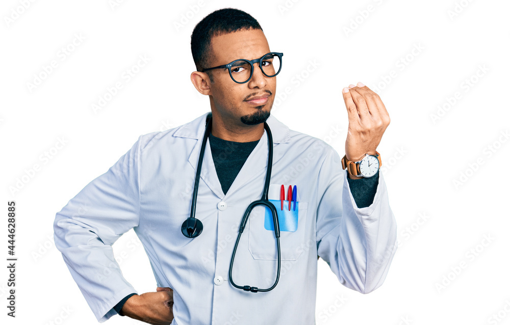 Young african american man wearing doctor uniform and stethoscope doing italian gesture with hand and fingers confident expression Young african american man wearing doctor uniform and stethoscope doing italian gesture with hand and fingers confident expression