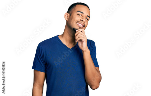 Young african american man wearing casual t shirt looking confident at the camera with smile with crossed arms and hand raised on chin. thinking positive.