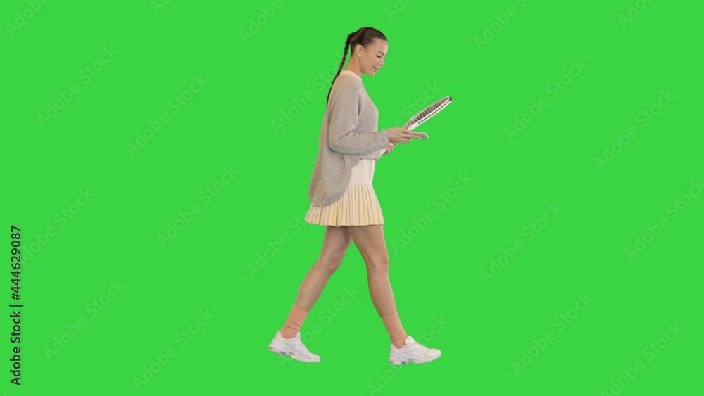 Pretty young female tennis player walking and using smart phone on a Green Screen, Chroma Key. Pretty young female tennis player walking and using smart phone on a Green Screen, Chroma Key.