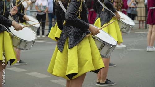 Young girls drummer in yellow black vintage uniform at parade. Street performance. Parade of majorettes