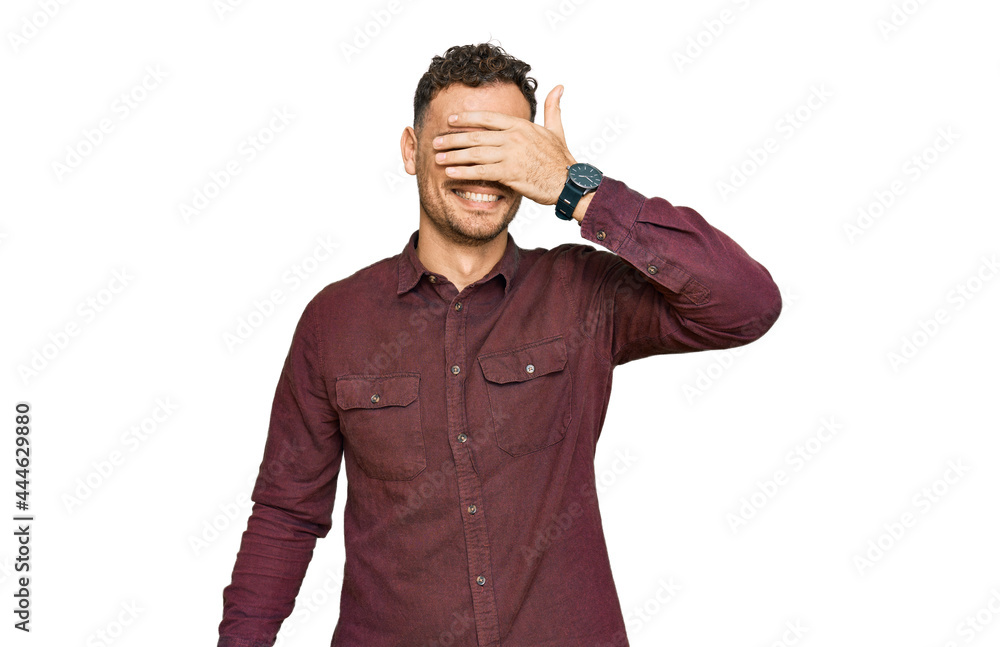 Young hispanic man wearing casual clothes smiling and laughing with hand on face covering eyes for surprise. blind concept.