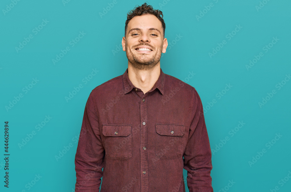 Fototapeta premium Young hispanic man wearing casual clothes with a happy and cool smile on face. lucky person.