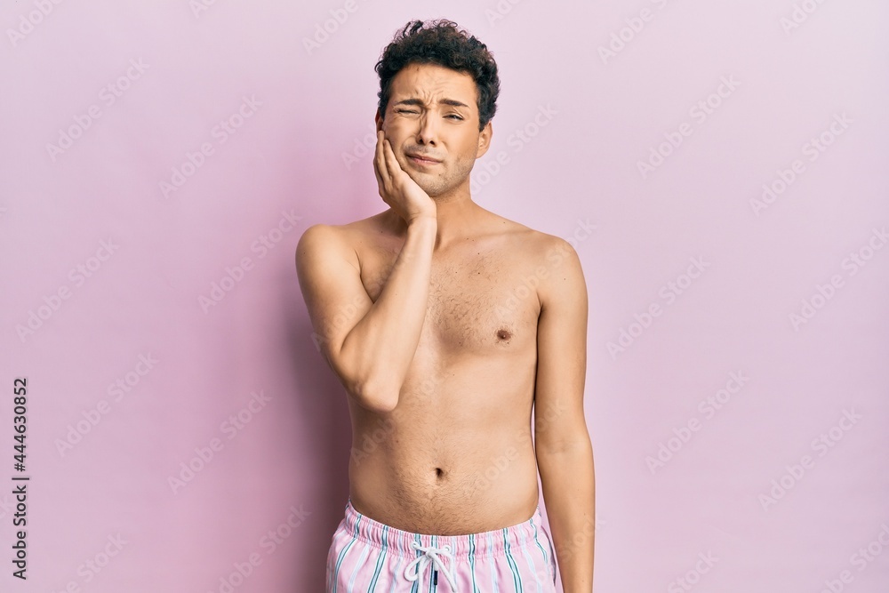 Fototapeta premium Young handsome man wearing swimwear shirtless touching mouth with hand with painful expression because of toothache or dental illness on teeth. dentist