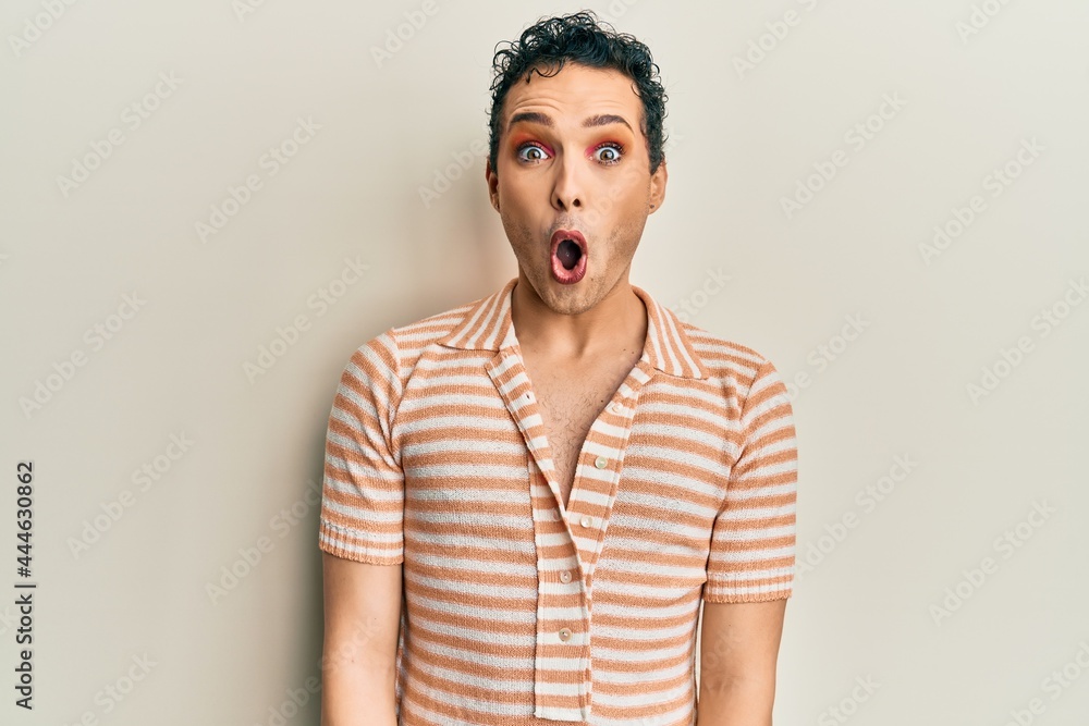 Handsome man wearing make up wearing casual t shirt afraid and shocked with surprise expression, fear and excited face.