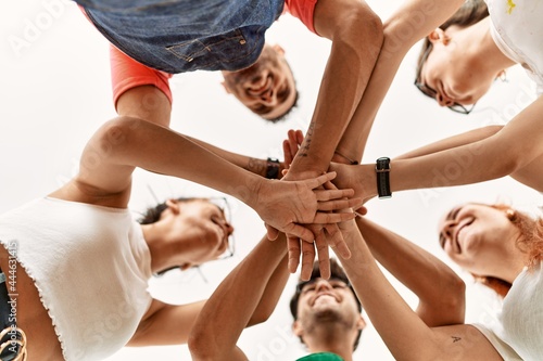 Group of young friends with hands together.