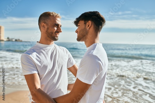 Romantic young gay couple at the beach.