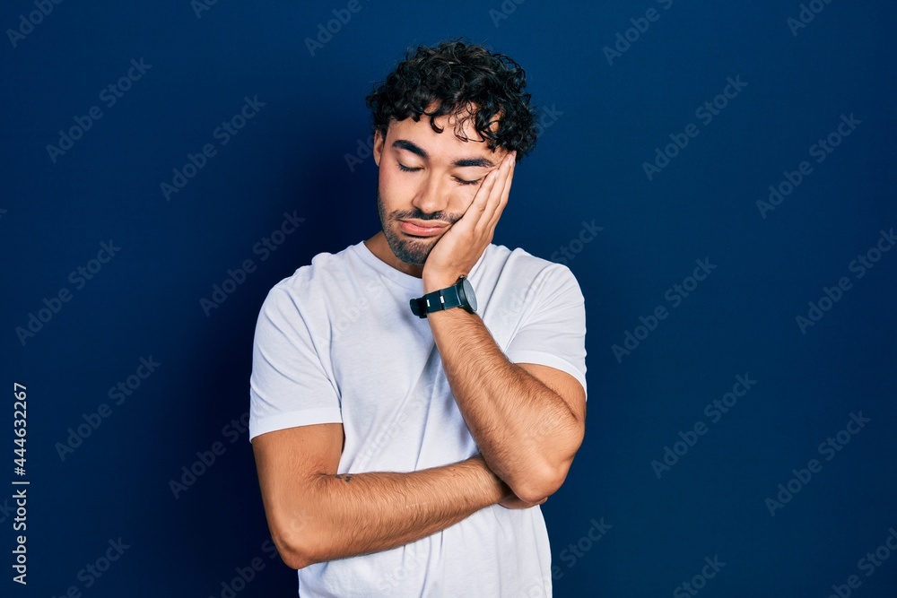 Young hispanic man wearing casual white t shirt thinking looking tired and bored with depression problems with crossed arms. Young hispanic man wearing casual white t shirt thinking looking tired and bored with depression problems with crossed arms.